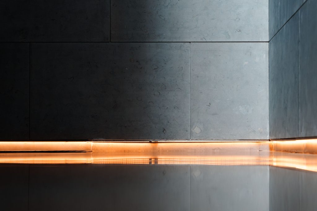 Modern interior showcasing sleek walls, reflective flooring, and ambient lighting for a serene atmosphere.